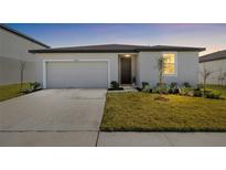 Charming single-story home featuring a two-car garage, manicured lawn, and a welcoming front entrance at 38602 Finn Clover Ln, Zephyrhills, FL 33540