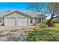 Charming single-story home featuring a two-car garage, landscaped yard, and welcoming front entrance at 39650 Us Highway 19 N # 244, Tarpon Springs, FL 34689