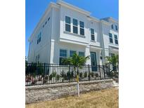 Beautiful two-story townhouse with a manicured front yard, black fence, and blue door at 4717 W Mccoy St # 9, Tampa, FL 33616