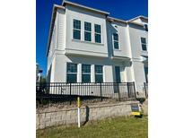 Modern two-story home featuring white stucco and siding, with large windows and a black metal fence at 4717 W Mccoy St # 9, Tampa, FL 33616