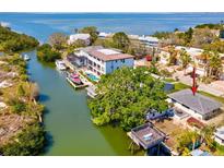 An aerial view of a waterfront home with a boat dock and lush landscaping on a sunny day at 4834 W Flamingo Rd, Tampa, FL 33611