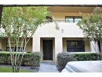 Inviting front entrance with a dark-colored door, landscaping and a textured facade, framed by trees at 4983 Puritan Cir # 524, Tampa, FL 33617