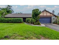 Charming single-story home featuring a lush front lawn, a blue two-car garage and an inviting entryway at 5101 Estates Cir, Sarasota, FL 34243