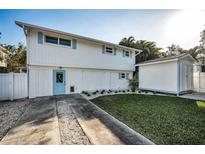 Charming two-story home with blue trim, a green lawn and a convenient storage shed at 7 Georgia Ave, Crystal Beach, FL 34681