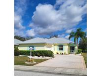 Charming single-story home with a well-manicured lawn, a two car garage, and a welcoming front entrance at 1318 Misty Greens Dr, Sun City Center, FL 33573