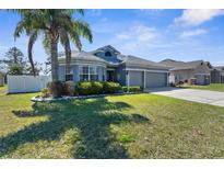 Charming single-Gathering home featuring lush landscaping, a well-manicured lawn, and a two-car garage at 13424 Hunters Point St, Spring Hill, FL 34609