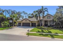 Charming home showcasing a three-car garage, and meticulously manicured landscaping at 3668 Janus Way, Palm Harbor, FL 34685