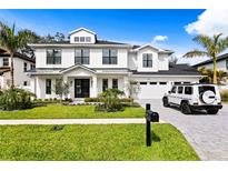 Beautiful two-story modern farmhouse with manicured lawn, black framed windows, and brick driveway at 3815 W Obispo St, Tampa, FL 33629