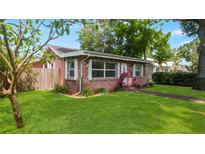 Charming single-story brick home featuring a well-manicured lawn and mature landscaping at 4424 19Th N St, St Petersburg, FL 33714