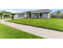 Charming home with a well-manicured lawn, lovely landscaping, and an attached two-car garage at 4714 Kemble Ct, Tampa, FL 33624