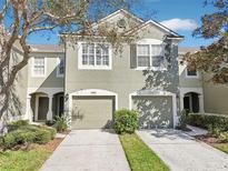 Charming townhome featuring a well-maintained lawn, attached garage, and neutral-tone exterior paint at 4806 Pond Ridge Dr, Riverview, FL 33578