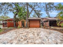 Charming home featuring a stone-paved driveway, a single garage, and a lovely carport at 799 Fairwood Ln, Clearwater, FL 33759