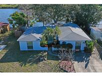 Waterfront home featuring a cozy front yard and lush landscaping at 1214 Stover Ct, Holiday, FL 34691