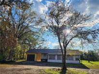 Charming single-story home featuring an attached garage and a quaint, tree-lined front yard at 1051 Hawthorn St, Zephyrhills, FL 33540