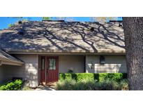 Charming front entrance with a red door and well-maintained landscaping at 1102 Old Mill Pond Rd, Palm Harbor, FL 34683
