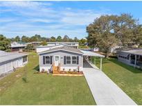 Charming home featuring a covered carport, landscaped yard, and a welcoming entrance at 14311 Action St, Brooksville, FL 34613