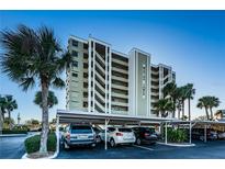 View of the Marina Tower condo building with parking and palm trees in the foreground under a bright blue sky at 2530 Gary Cir # 401, Dunedin, FL 34698