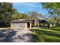 Charming single-story home with a stone facade, a brick driveway, and mature landscaping at 3416 S 70Th St, Tampa, FL 33619