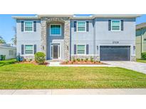 Beautiful home with a stone facade, manicured lawn, and a two-car garage at 3709 W Dale Ave, Tampa, FL 33609
