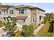 Two-story home features stone accents, neutral color palette, well maintained landscaping, and attached one car garage at 6930 Ripple Pond Loop, Zephyrhills, FL 33541