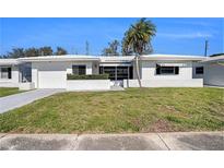Charming single story home with a well manicured lawn, white exterior, and a single car garage at 10047 41St N St # 10047, Pinellas Park, FL 33782