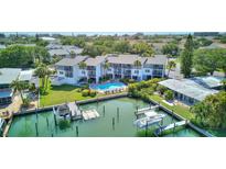 Beautiful condo complex featuring waterfront access, a community pool, and lush landscaping at 12055 3Rd E St # 103, Treasure Island, FL 33706