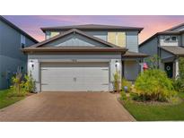 Two-story home featuring a brick driveway and attached two-car garage at 17805 Everlong Dr, Land O Lakes, FL 34638