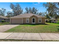 Charming single-story home with an attached two-car garage and a well-maintained front lawn at 2156 Deltona Blvd, Spring Hill, FL 34606