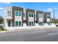 Modern townhome exterior features a gray and white facade with a white picket fence and street view at 2808 N Florida Ave, Tampa, FL 33602