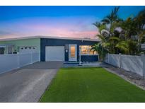 Charming single-story home with a manicured lawn, attached garage, and beautiful landscaping at 423 62Nd St, Holmes Beach, FL 34217