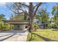 Charming home featuring a covered carport and lush landscaping surrounding the property at 206 W Minnehaha St, Tampa, FL 33604