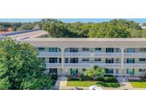 Condo building featuring multiple units with balconies, lush greenery, and nearby parking at 2253 Norwegian Dr # 67, Clearwater, FL 33763