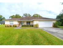 Charming single-story home featuring a well-maintained lawn, attached two-car garage, and welcoming front porch at 22941 Leafwood Ct, Land O Lakes, FL 34639