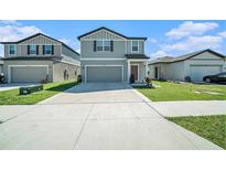 Charming two-story home with an attached garage, manicured lawn, and neutral-colored exterior with a driveway at 35542 Buttonweed, Zephyrhills, FL 33541