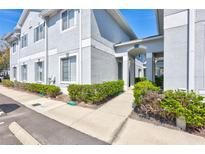 Light gray two-story condo with manicured bushes near the walkway to the main entrance at 4106 Waterside Island Ct, Tampa, FL 33617