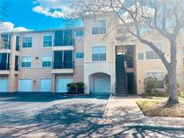 Attractive condo building featuring private garages, covered balconies, and lush landscaping at 5125 Palm Springs Blvd # 1203, Tampa, FL 33647