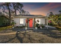 Charming single-story home with a vibrant pink door and well-maintained gravel landscaping at 6202 Tennessee Ave, New Port Richey, FL 34653