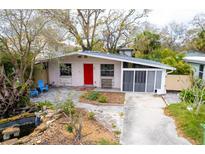 Charming single-story home with a red door, a well-manicured front yard, and a carport at 6713 S Mascotte St, Tampa, FL 33616