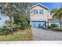 Charming two-story townhome with blue accents, paved driveway, and nicely landscaped front yard at 1109 Lady Gouldian Ct, Tampa, FL 33613