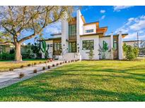 Modern two-story home boasting clean lines, wood accents, and a well-manicured lawn at 1401 Brightwaters Ne Blvd, St Petersburg, FL 33704