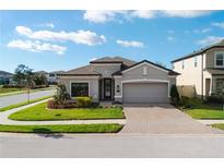 Charming single-story home with a brick-paved driveway and well-manicured lawn at 1593 Secluded Garden Ln, Lutz, FL 33558