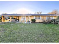 Charming single-story home with a covered carport, a well-maintained lawn, and an inviting front entrance at 18401 Hamilton Rd, Dade City, FL 33523
