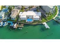 Stunning aerial view of a waterfront home with a private pool and boat dock at 210 Dolphin Pt # B, Clearwater Beach, FL 33767
