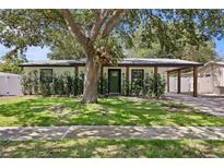 Charming single-story home with lush landscaping and a welcoming front entrance and covered parking at 2912 W Winthrop Rd, Tampa, FL 33611