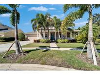 Charming two-story home with a manicured lawn, lush landscaping, and inviting front porch at 5616 Seagrass Pl, Apollo Beach, FL 33572