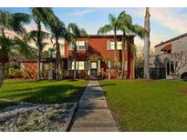 Charming two-story home with mature landscaping and inviting walkway to the front door at 681 Jasmine S Way, St Petersburg, FL 33705