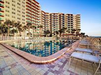 Resort-style pool deck with inviting lounge chairs overlooking the beautiful tower residences and blue skies at 880 Mandalay Ave # C412, Clearwater Beach, FL 33767