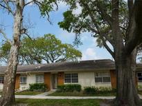 Charming single-story home features a well-maintained lawn, inviting entrance, and mature trees for shade at 2297 Lark E Cir # E, Palm Harbor, FL 34684