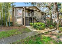 Inviting two-story home with well-maintained landscaping and exterior staircase to front door at 14211 Shadow Moss Ln # 101, Tampa, FL 33613