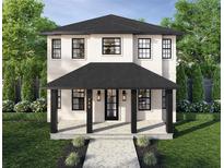Charming two-story home featuring a covered porch, black framed windows, and well manicured landscaping at 2711 13Th N St, St Petersburg, FL 33704